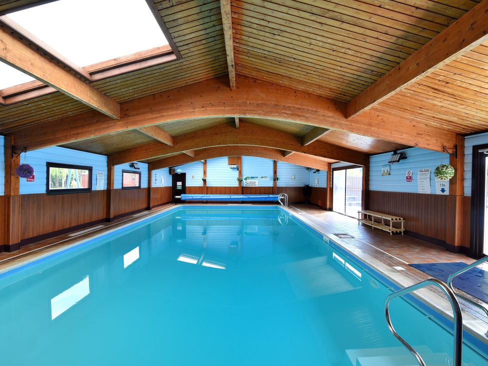 An indoor pool area with wooden ceiling at Cedar 1 Pinewood Retreat