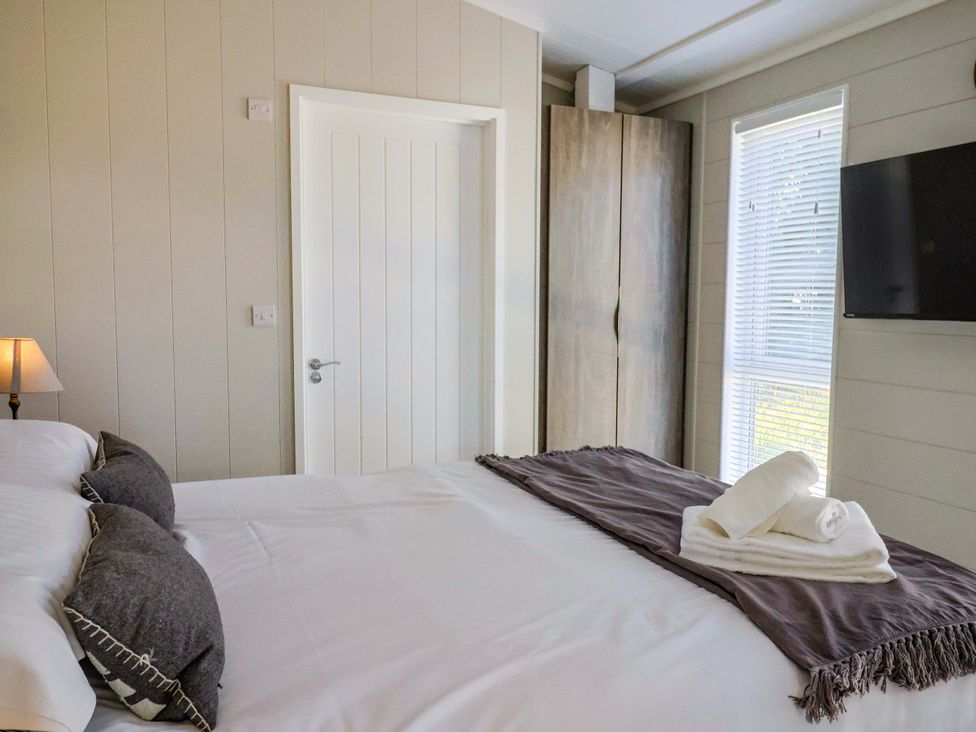 A bedroom with a bed and a window at Cedar 1 Pinewood Retreat in Rousdon near Lyme Regis