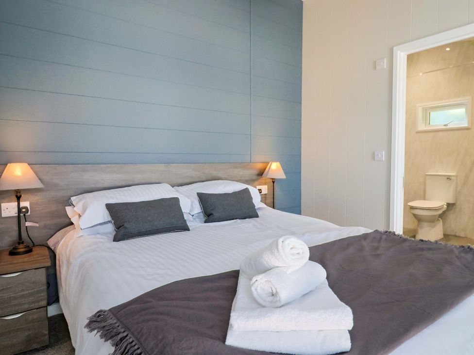 A bedroom with bed and adjoining toilet at Cedar 1 Pinewood Retreat in Rousdon near Lyme Regis