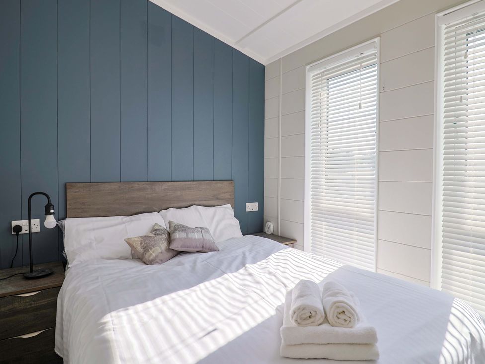 A bedroom with a bed and pillows at Cedar 1 Pinewood Retreat in Rousdon near Lyme Regis
