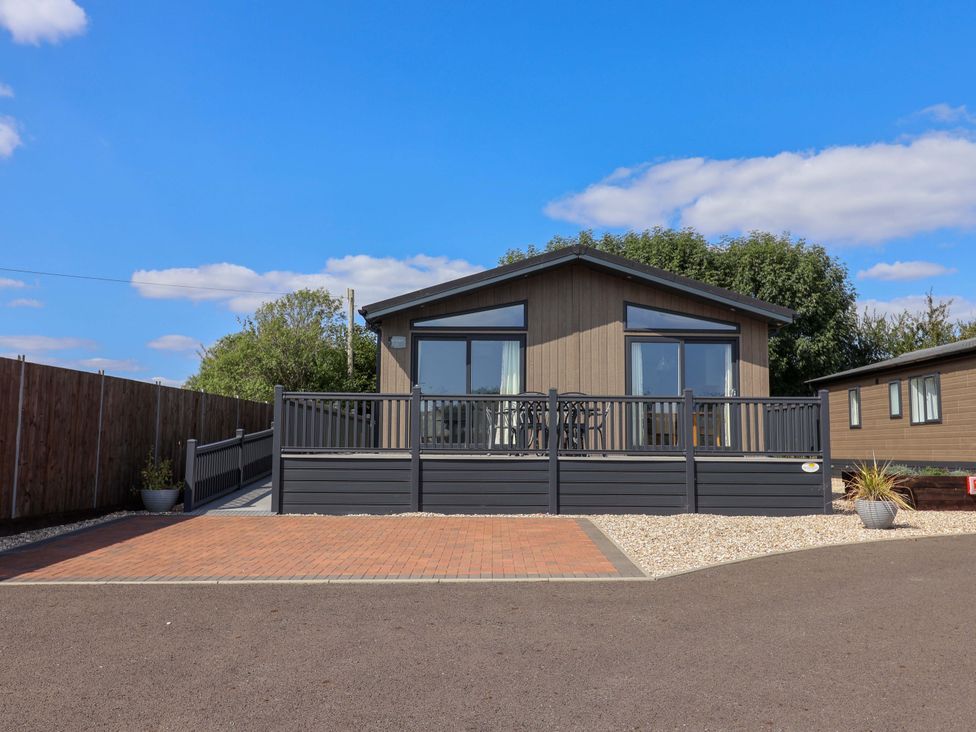 A cabin with a deck and driveway at Cedar 1 Pinewood Retreat in Rousdon near Lyme Regis