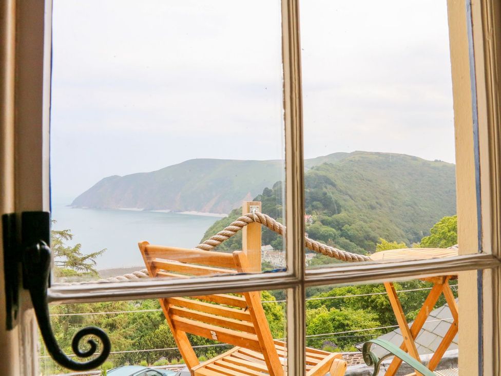 A view of the sea and mountains through a window at Baywatch (St. David's View) in Lynton