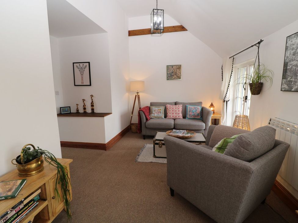 A living room featuring a sofa, coffee table, and lamp at Baywatch (St. David's View) Lynton
