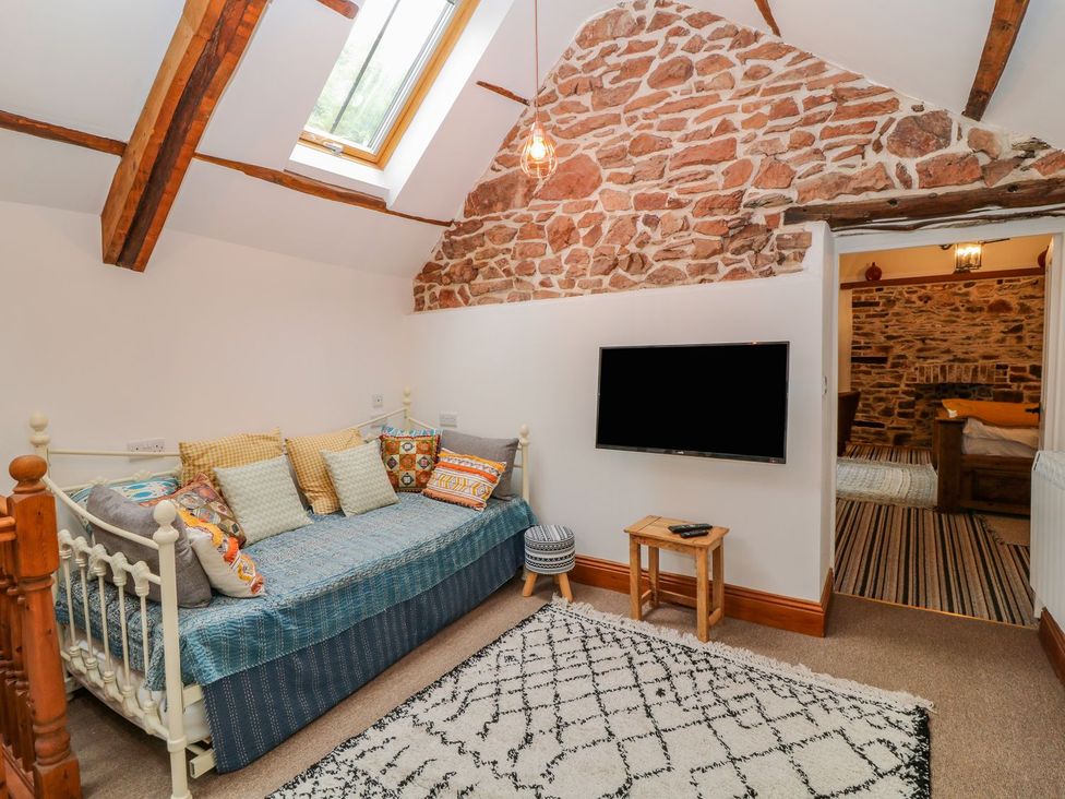 A living room with a sofa bed and television at Baywatch (St. David's View) Lynton