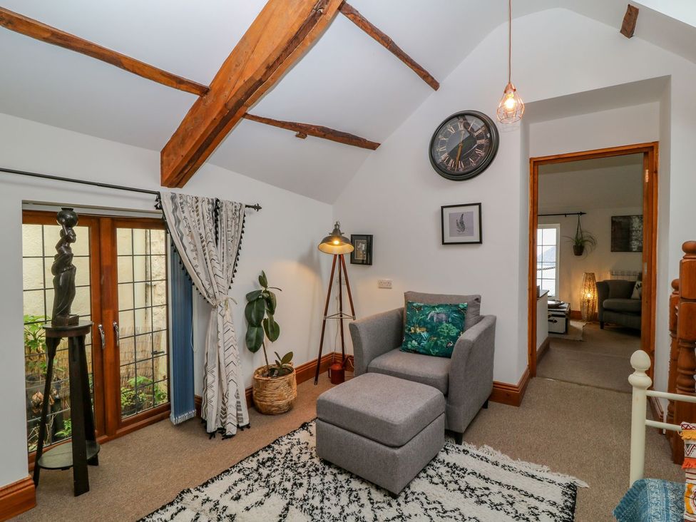 A sitting room with an armchair and ottoman at Baywatch (St. David's View) Lynton