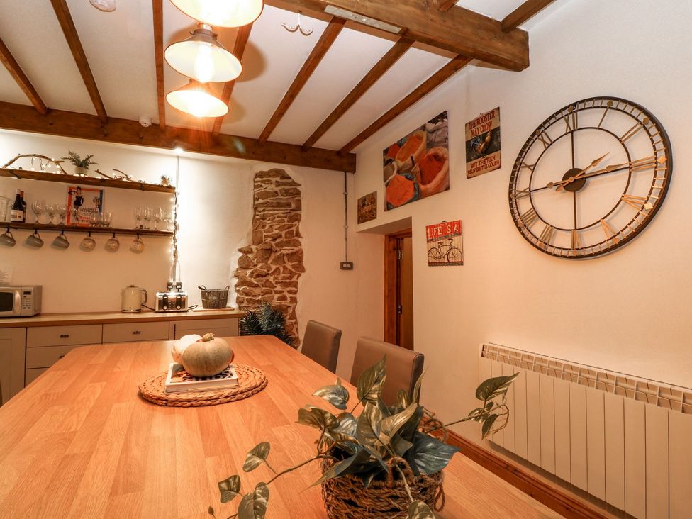 A kitchen with a wooden table and shelves at Baywatch (St. David's View) Lynton