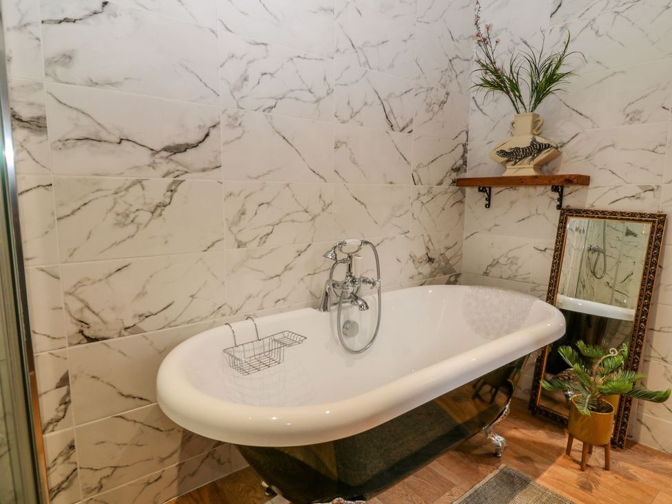 A bathroom with a bathtub and tiles at Baywatch (St. David's View) Lynton
