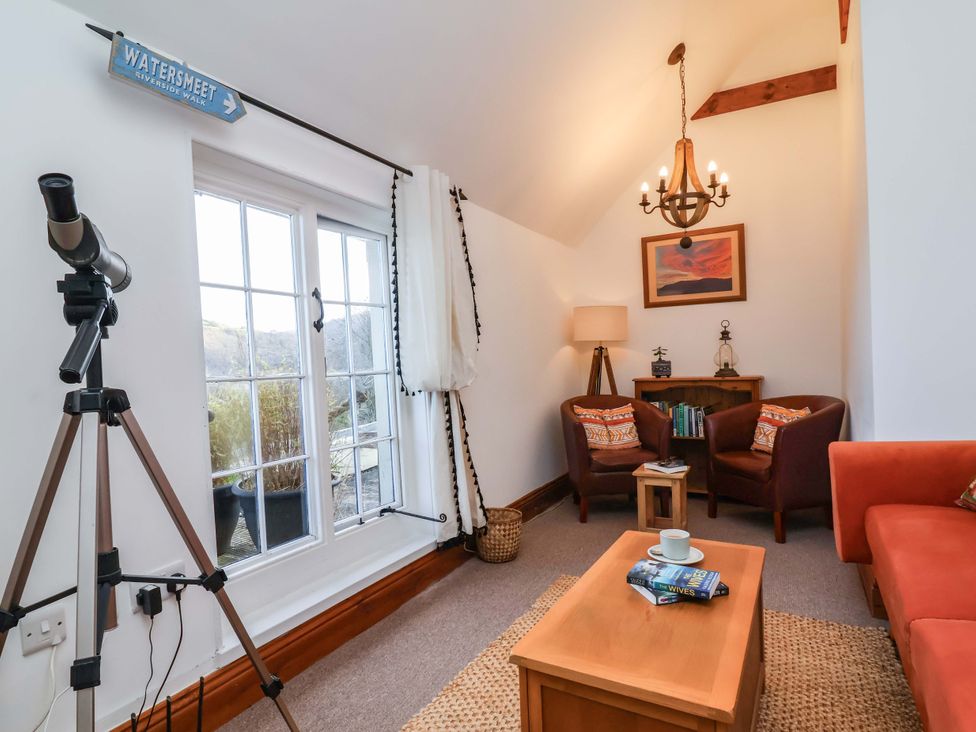 A living room with a telescope and bookshelves at Baywatch (St. David's View) Lynton