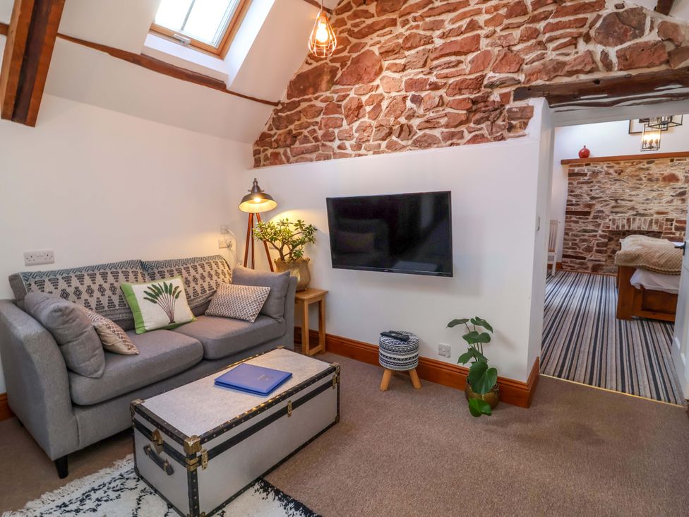 A living room with a sofa and television at Baywatch (St. David's View) Lynton