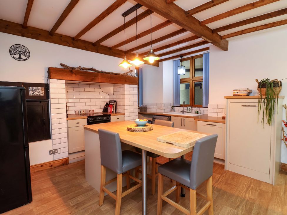 A kitchen with a dining table and various appliances at Baywatch (St. David's View) Lynton