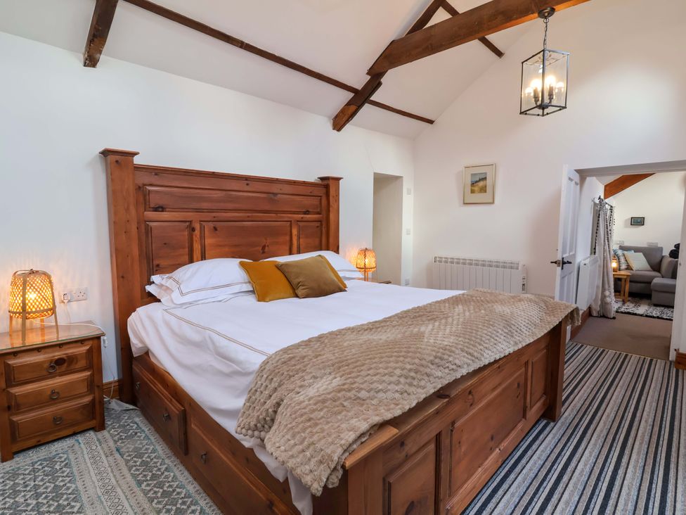 A bedroom with a wooden bed and nightstand at Baywatch (St. David's View) Lynton