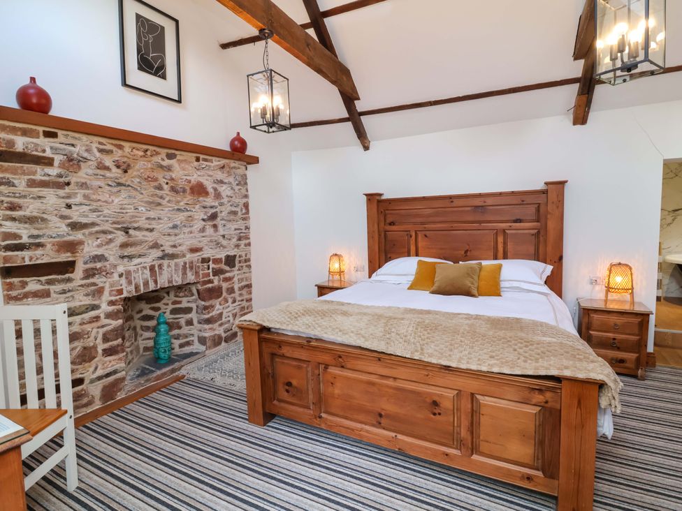 A bedroom with a wooden bed and nightstands at Baywatch (St. David's View) in Lynton