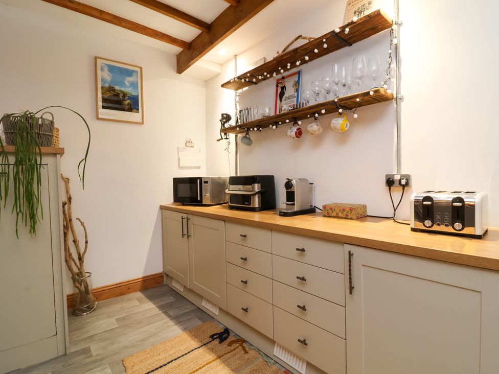 A kitchen with cabinets and appliances at Baywatch (St. David's View) Lynton