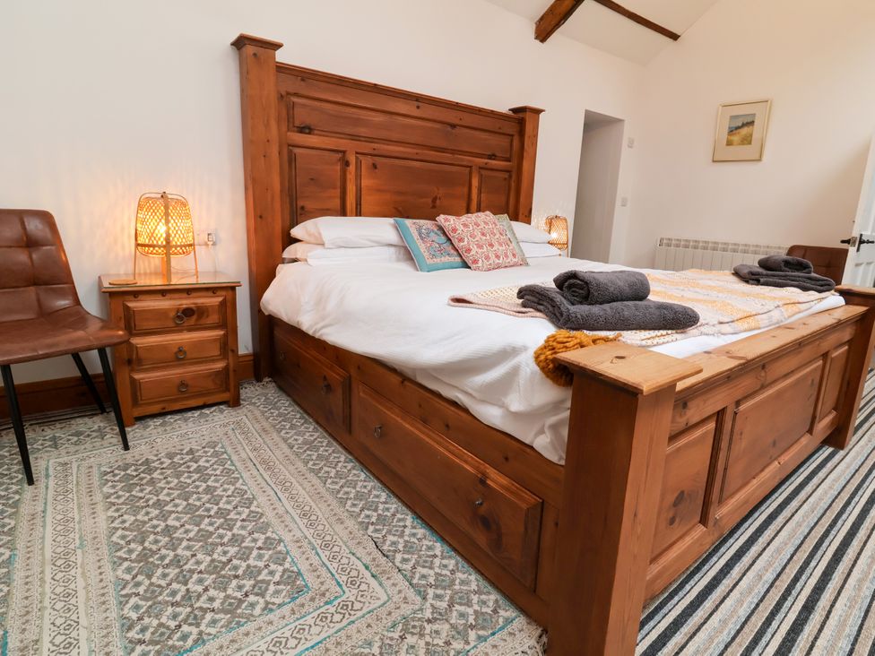A bedroom with a wooden bed and nightstand at Baywatch (St. David's View) Lynton