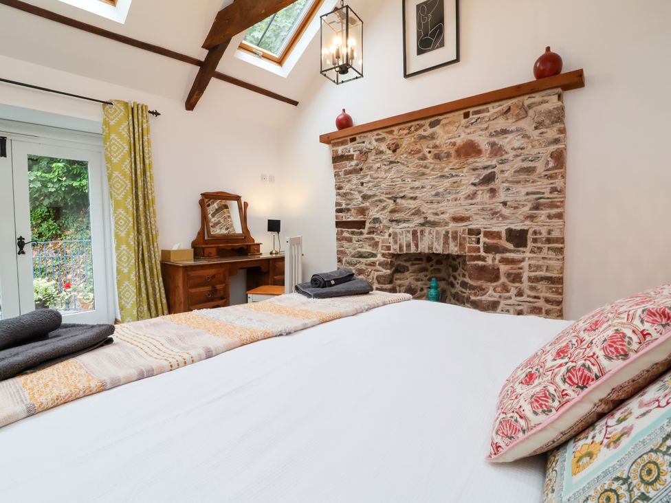 A bedroom with a bed, fireplace, and a desk at Baywatch (St. David's View) Lynton