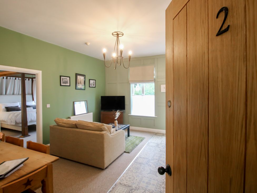 A living room with a couch and television at Apartment 2 The Bridge at Stanford Hotel near Great Witley