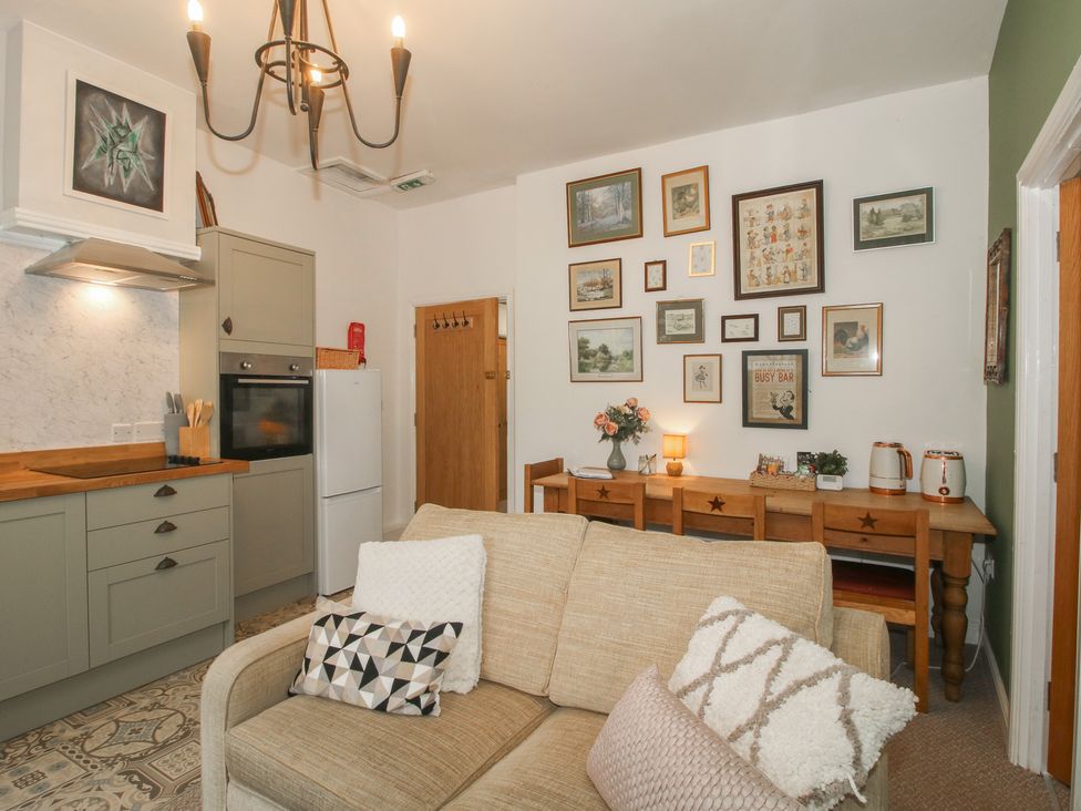 A living room with a sofa and dining table at Apartment 2 The Bridge at Stanford Hotel near Great Witley