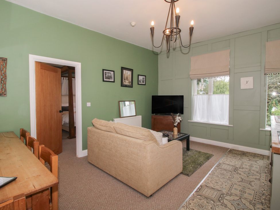 A living room with a sofa and television at Apartment 2 The Bridge at Stanford Hotel near Great Witley