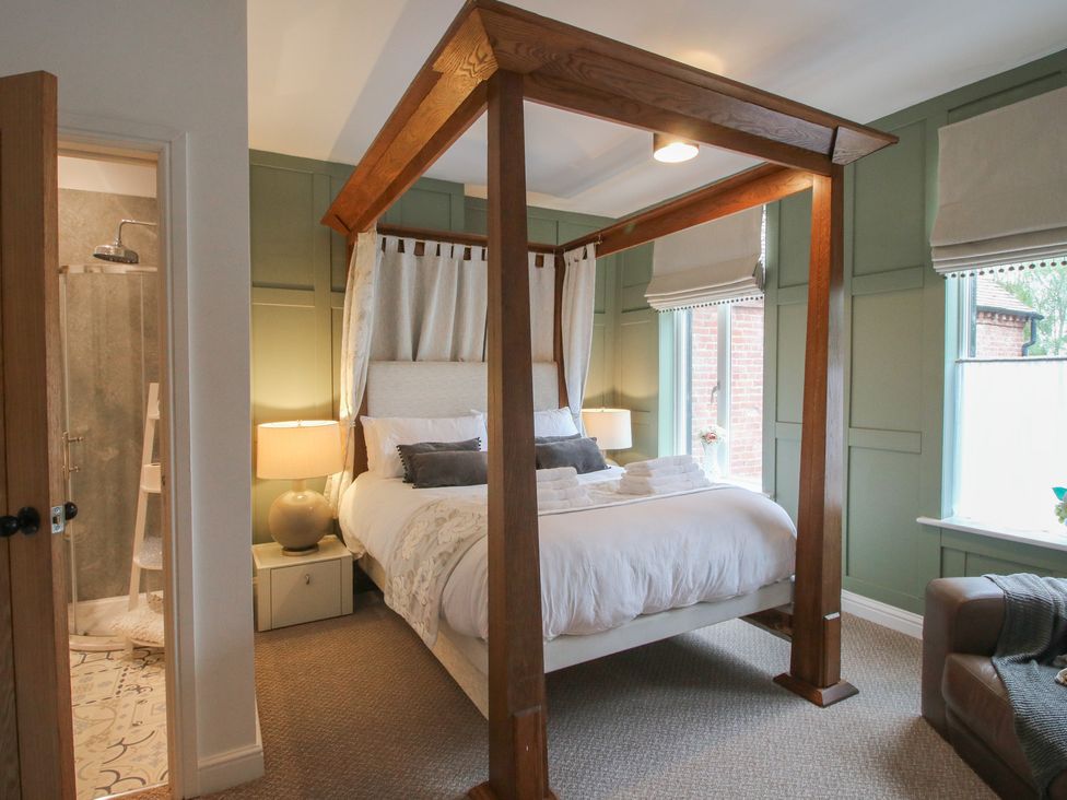 A bedroom with a canopy bed and a shower area at Apartment 2 The Bridge at Stanford Hotel near Great Witley
