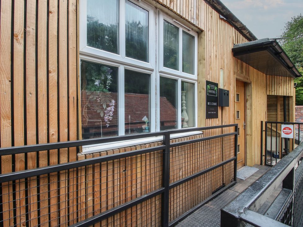 An entrance with wooden walls and a sign at Apartment 2 The Bridge at Stanford Hotel near Great Witley