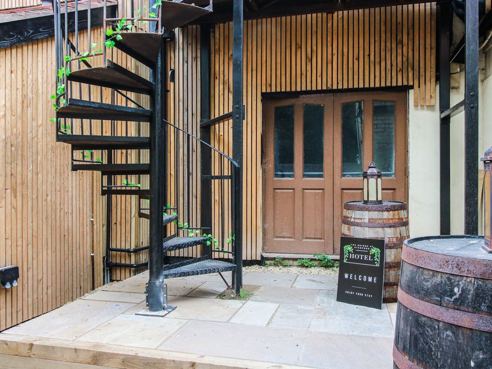 An outdoor area with a spiral staircase and a welcome sign at Apartment 1 The Bridge at Stanford Hotel near Great Witley