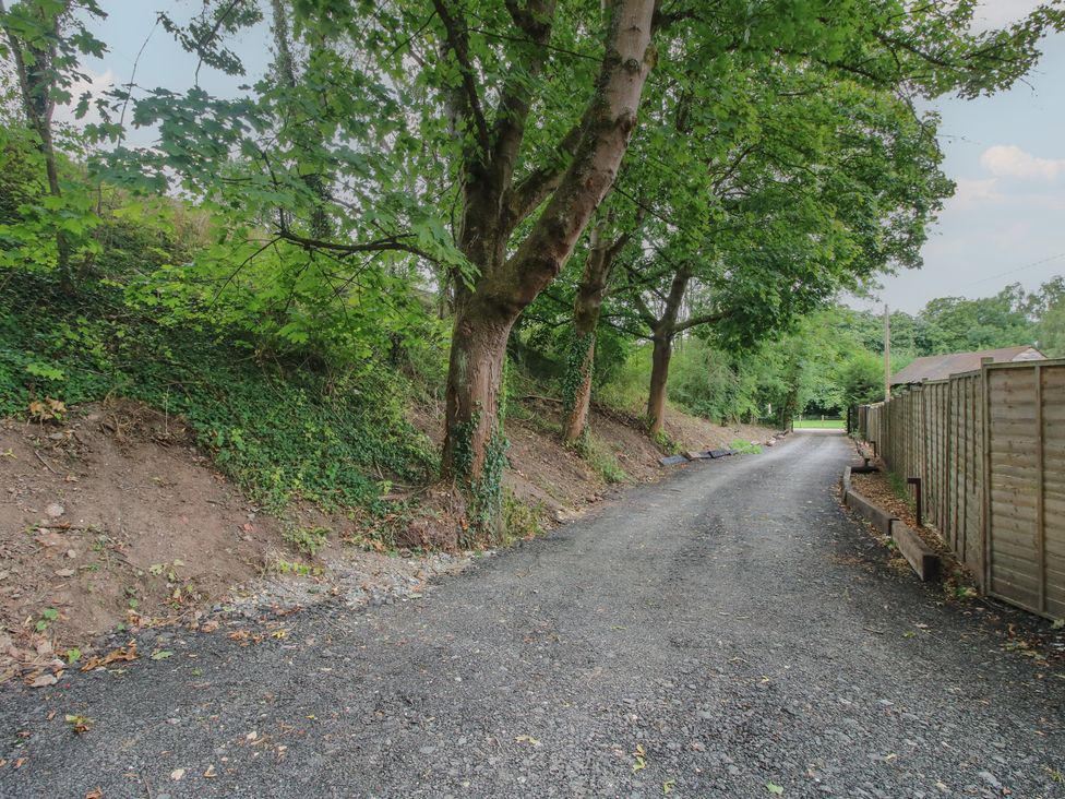 A gravel road bordered by trees and a fence at Apartment 1 The Bridge at Stanford Hotel near Great Witley