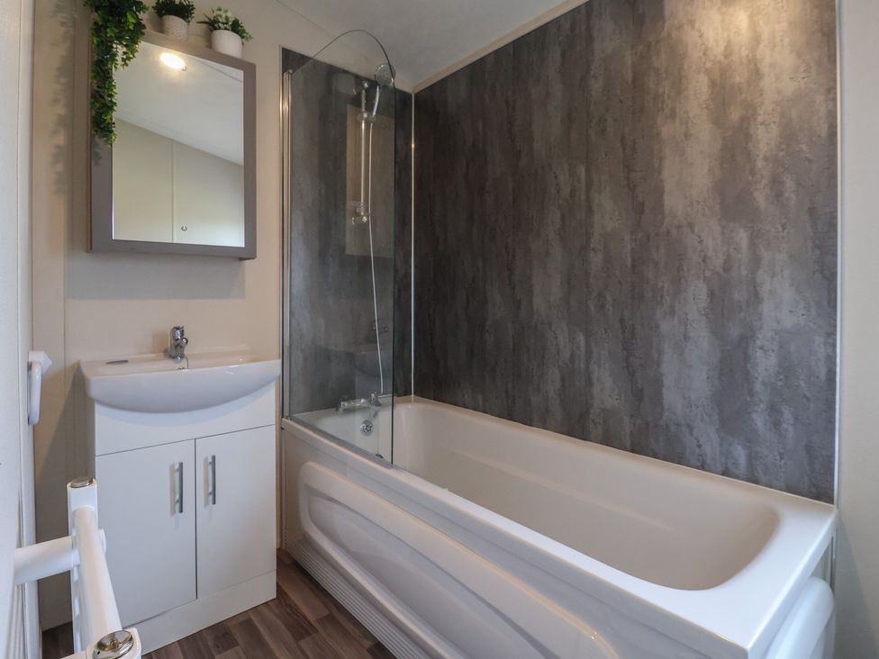A bathroom with a bath tub and sink at Meadows Park 2 in Great Hatfield near Hornsea