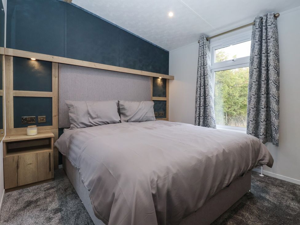 A bedroom with a bed and window at Meadows Park 2 Great Hatfield near Hornsea