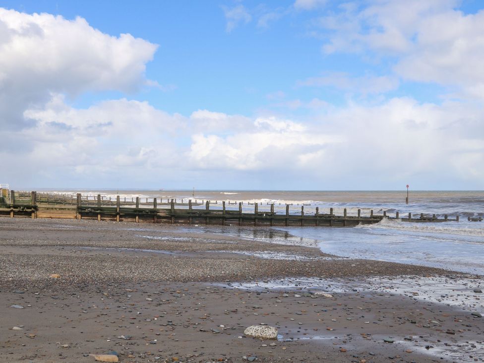 A beach with a pier and waves at Meadows Park 2 Great Hatfield near Hornsea