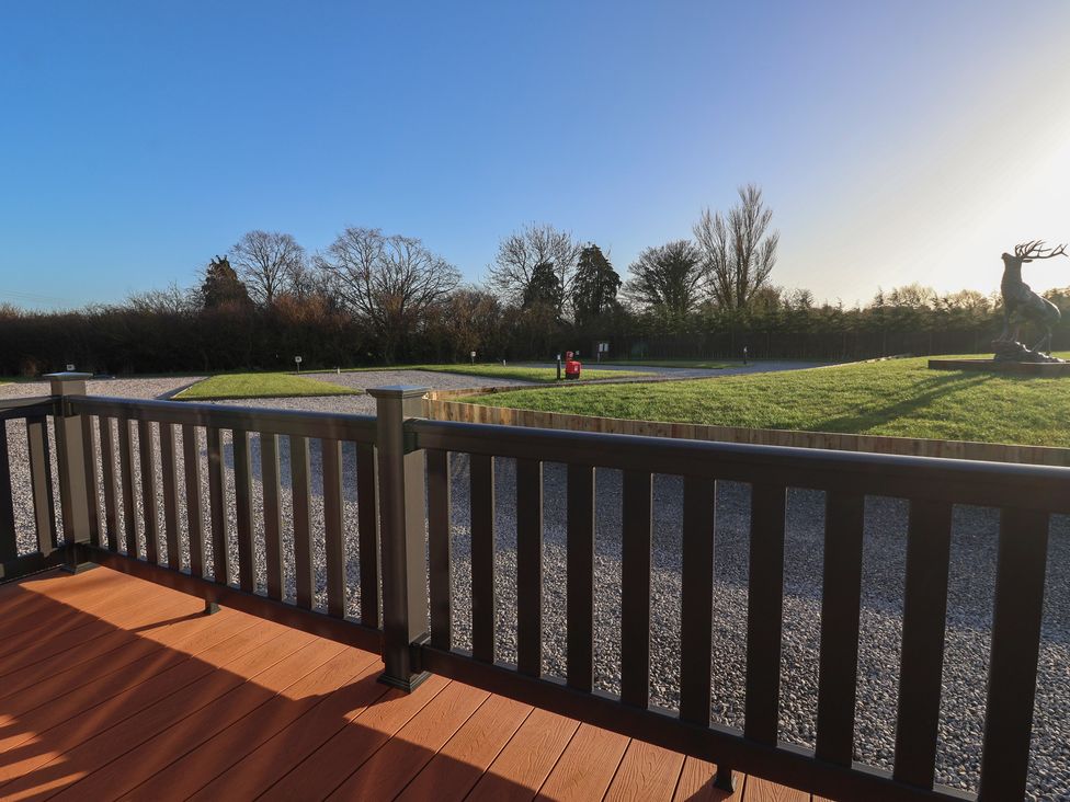 A view from a deck overlooking a grassy area with a statue at Meadows Park 2 Great Hatfield near Hornsea