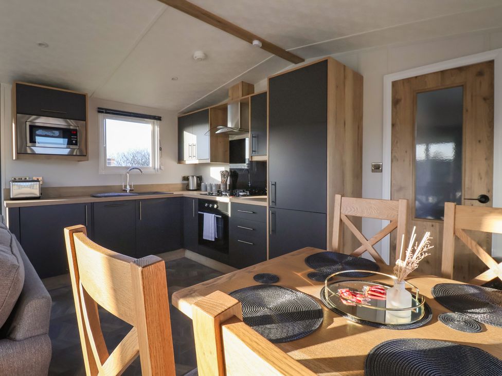 A kitchen with appliances and dining area at Meadows Park 2 Great Hatfield near Hornsea