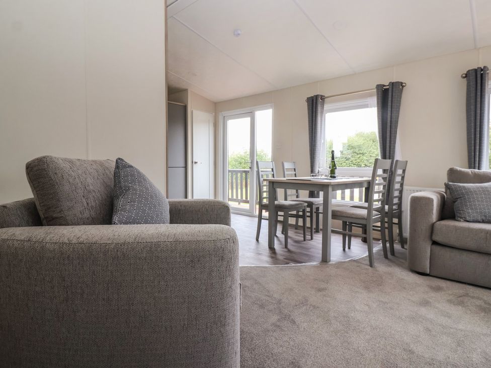 A living room with a sofa and dining area at Meadows Park 3 Great Hatfield near Hornsea