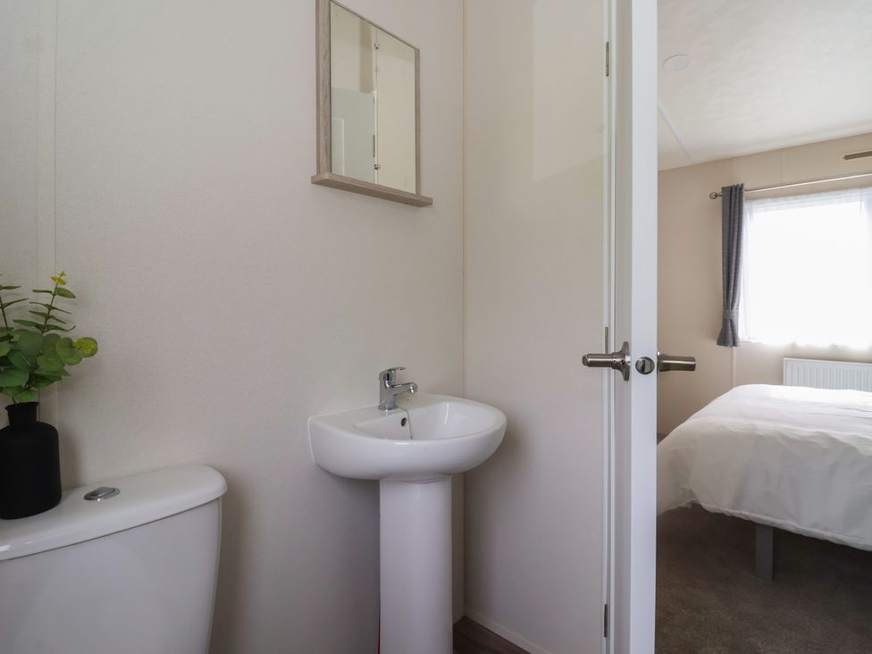 A bathroom area with a toilet and sink at Meadows Park 3 Great Hatfield near Hornsea