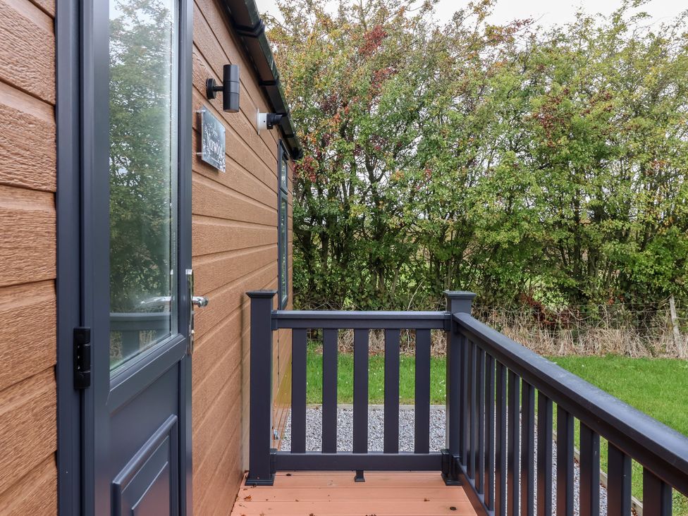 An outdoor deck area with a door and light fixture at Meadows Park 3 Great Hatfield near Hornsea
