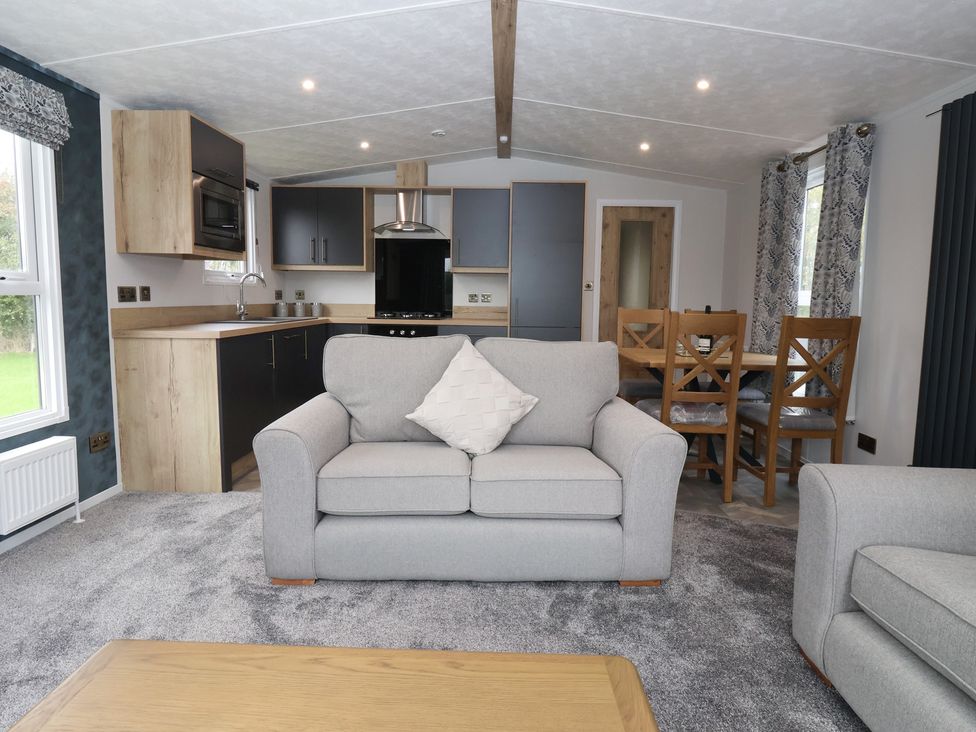 A living room with a sofa and dining area at Meadows Park 3 Great Hatfield near Hornsea