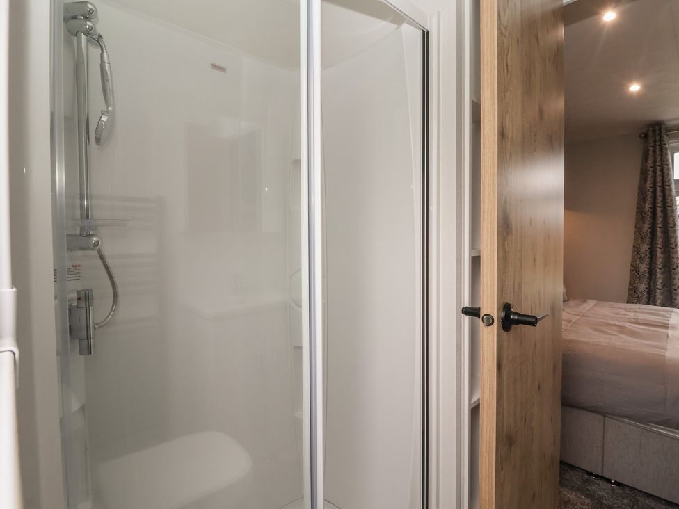 A bathroom with a shower and door at Meadows Park 3, Great Hatfield near Hornsea