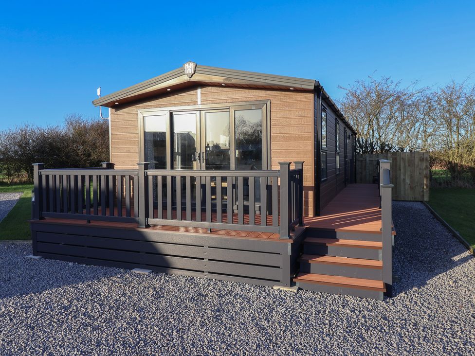 A cabin with a deck and steps at Meadows Park 3 Great Hatfield near Hornsea