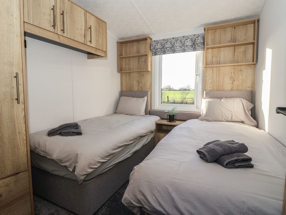 A bedroom with twin beds and shelves at Meadows Park 3 Great Hatfield near Hornsea