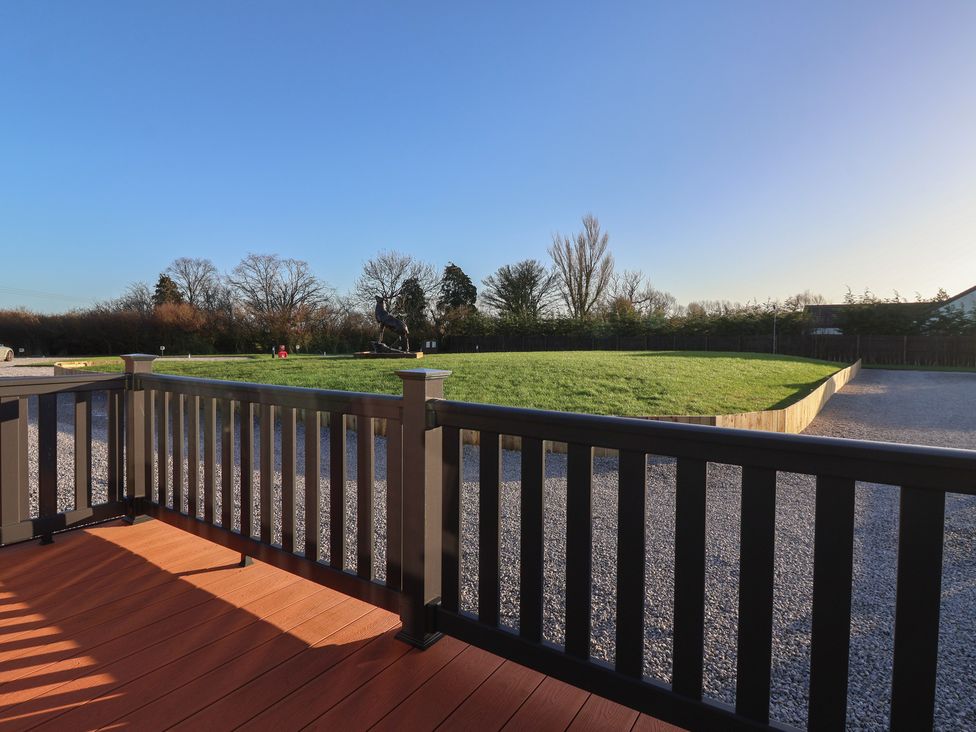An outdoor area with a deck overlooking a grassy space at Meadows Park 3 Great Hatfield near Hornsea