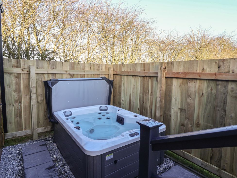 A hot tub surrounded by a wooden fence at Meadows Park 3 Great Hatfield near Hornsea