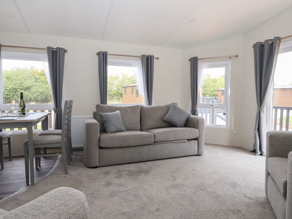 A living room with a sofa and dining table at Meadows Park 4 in Great Hatfield near Hornsea