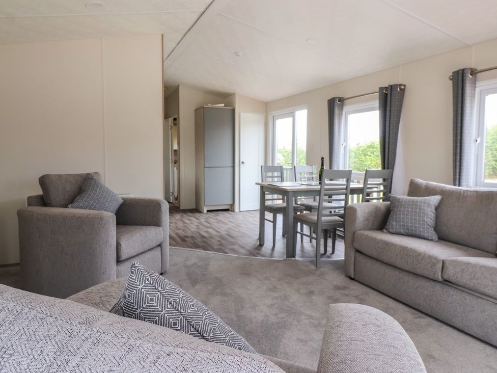 A living room with a sofa and dining area at Meadows Park 4 in Great Hatfield near Hornsea