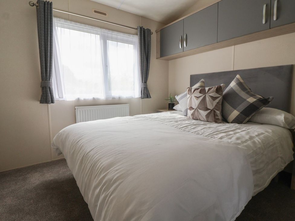 A bedroom with a bed and window at Meadows Park 4 Great Hatfield near Hornsea