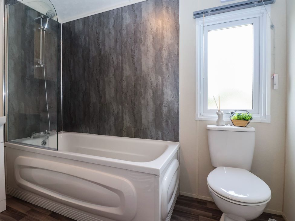 A bathroom with a bathtub and toilet at Meadows Park 4 Great Hatfield near Hornsea