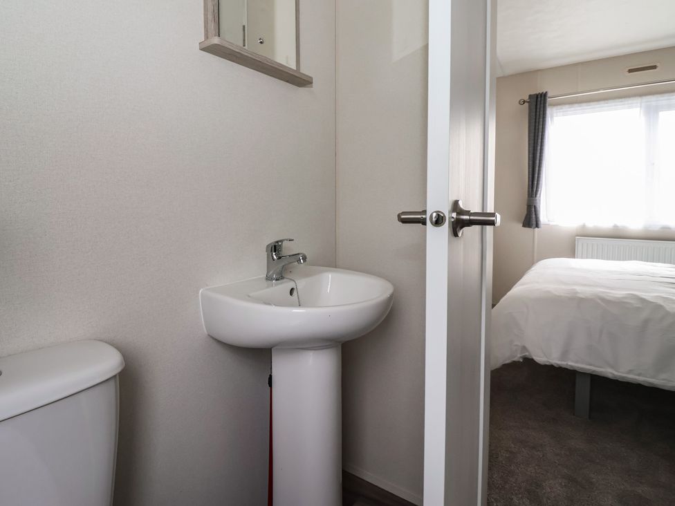 A bathroom with a toilet and sink at Meadows Park 4 Great Hatfield near Hornsea