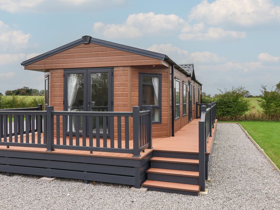 An outdoor area with a cabin and deck at Meadows Park 4 Great Hatfield near Hornsea