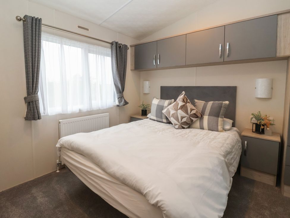 A bedroom with a bed and wall cabinet at Meadows Park 4 in Great Hatfield near Hornsea
