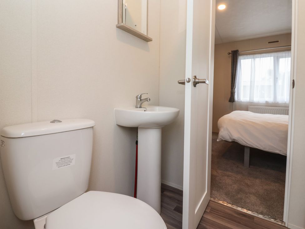 A bathroom with a toilet and sink at Meadows Park 4 Great Hatfield near Hornsea