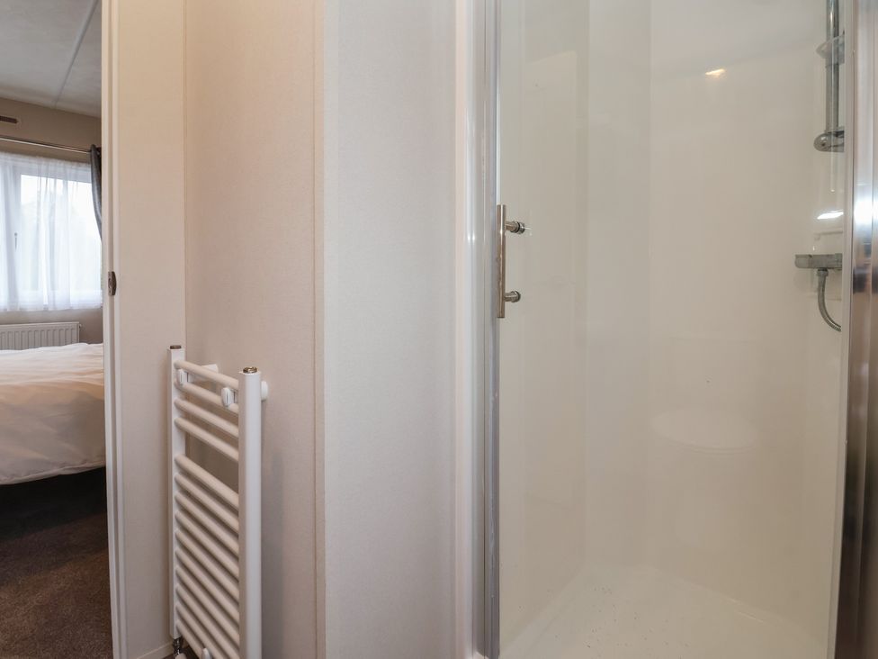 A bathroom with a shower and radiator at Meadows Park 4 Great Hatfield near Hornsea