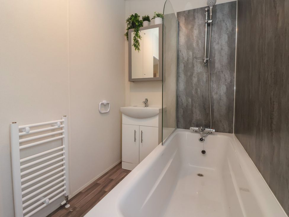 A bathroom with a bathtub and a vanity unit at Meadows Park 4 in Great Hatfield near Hornsea